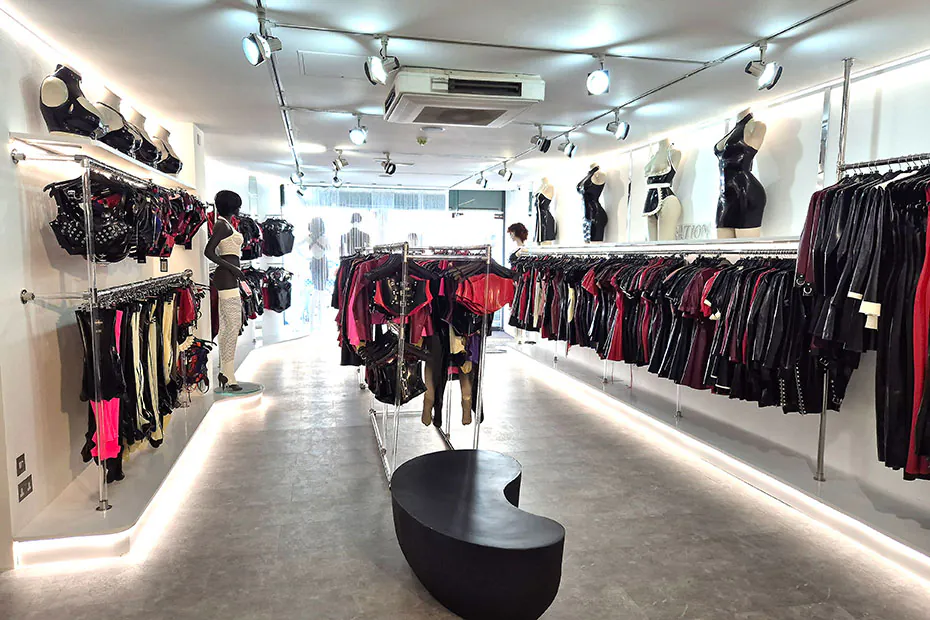Wall-mounted latex harnesses and bras above rails of coloured latex on the women’s floor.